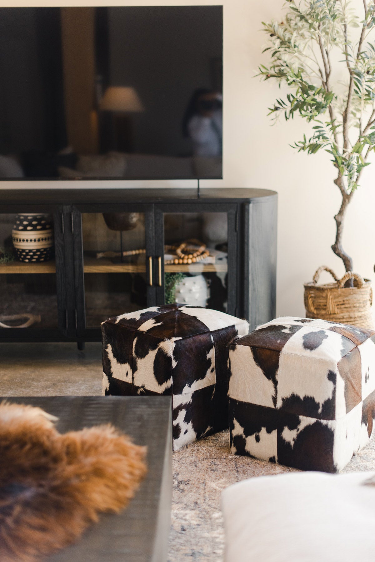 Cow skin stools in front of TV stand